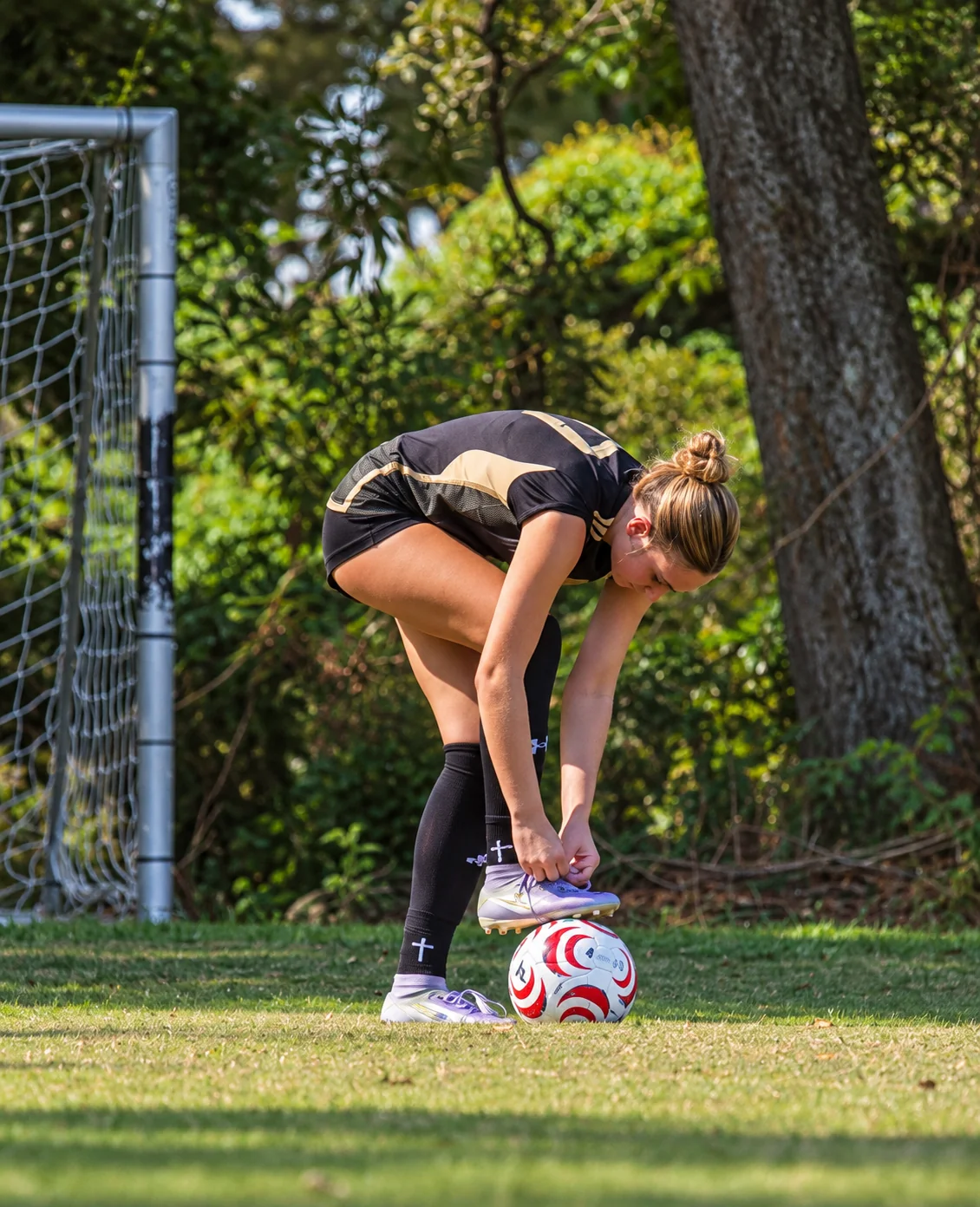 Catherine Page lacing her cleats over the ball